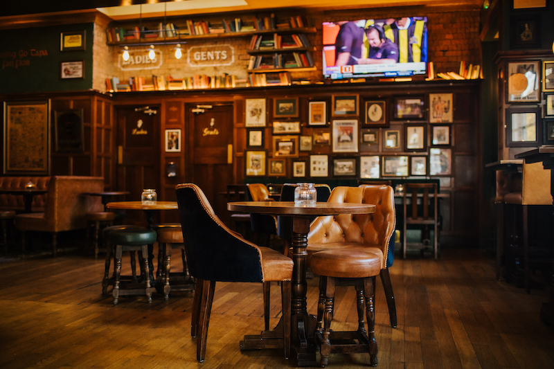 Interior of The Hanbury Islington, showing multiple screens and vibrant atmosphere.